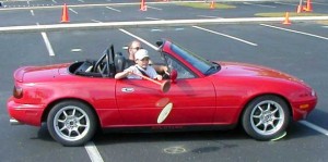 Boy in Miata tries to pick plate up off ground with toilet plunger